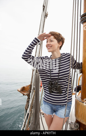 Mitte der erwachsenen Frau am Meer im Segelboot suchen Stockfoto