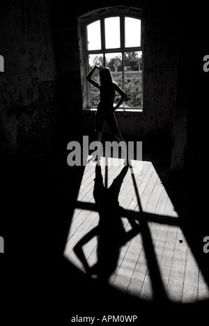 Silhouette und Schatten eines Womans Körper vor einem Fenster Stockfoto