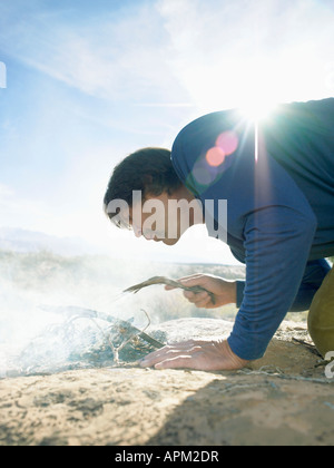 Mann Beleuchtung Feuer auf Rock, Low Angle View Stockfoto