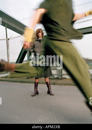 Frau stehend auf Brücke, Mann läuft Stockfoto