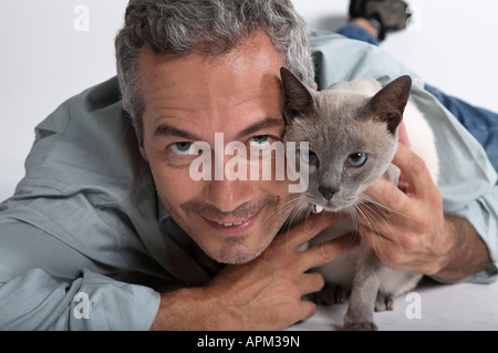 Mann mit siamesische Katze Stockfoto