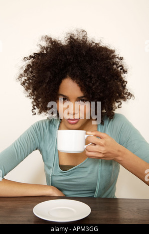 Junge Frau trinken Kaffee, Porträt Stockfoto