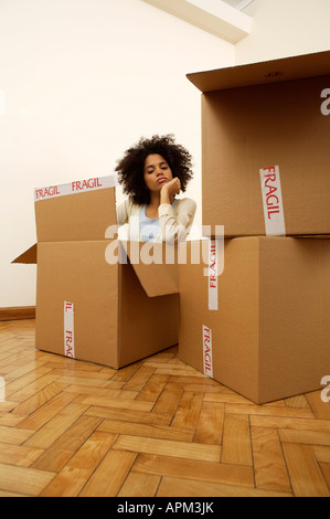 Junge Frau in einem cardbox Stockfoto