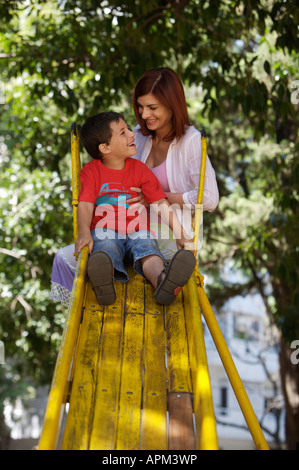 Mutter und Kinder auf Spielplatz Stockfoto