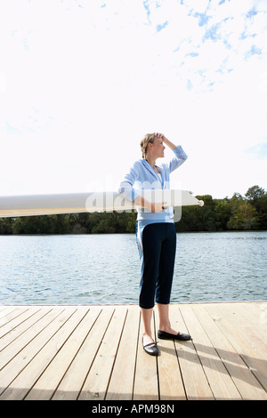 Junge Frau mit Segel boom auf Pier Stockfoto