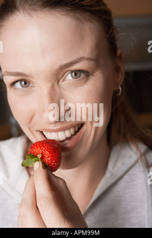Junge Frau essen Erdbeere (Hochformat) Stockfoto