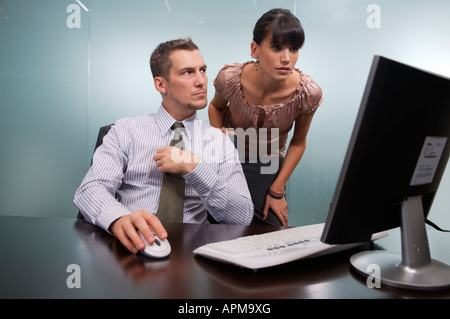 Business-Mann und Frau sprechen neben einem Computer-display Stockfoto