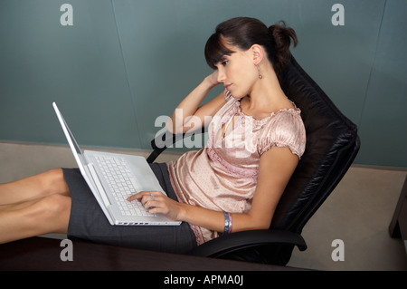 Business-Frau mit ihren Füßen auf dem Tisch mit ihrem Notebook-computer Stockfoto
