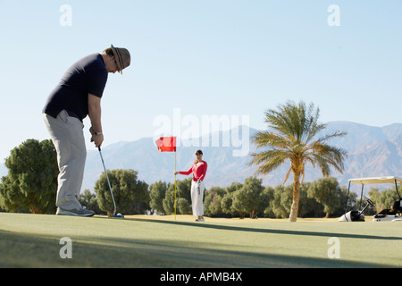 Zwei Menschen, die Golf spielen am Golfplatz Stockfoto