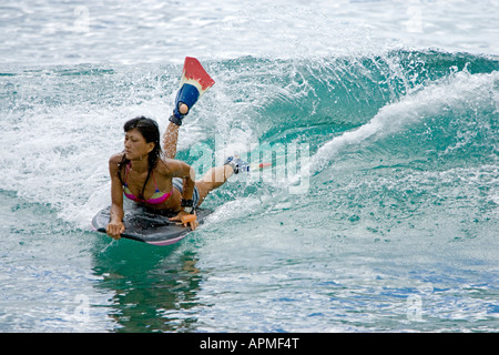 Junge Frau Wave Rider Bodyboard in Surf Waikiki Beach Honolulu Hawaii USA Stockfoto