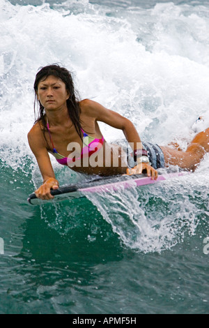 Junge Frau Wave Rider Bodyboard in Surf Waikiki Beach Honolulu Hawaii USA Stockfoto