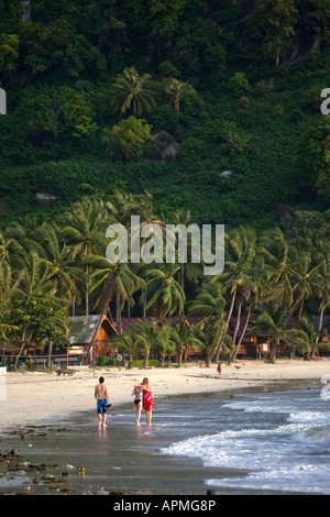 Junge Menschen gehen in Wellen am Rand des Wassers Hat Rin Nok Sunrise Beach Ko Pha Ngan Thailand Stockfoto