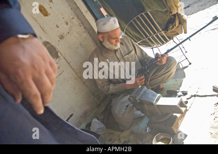 Ein Alter Mann bei der Arbeit, die den Lauf einer Riffelung in Darra Adam Hel Pakistan Polieren Stockfoto