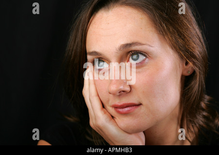 Brünette Frau Hand auf Wange zufrieden glücklich entspannt Ferne wehmütig Tagträumen kontemplativen reflektierende nachdenklich Wunschdenken Stockfoto