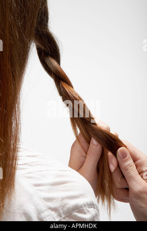 Junge Frau, die ihr Haar (Rückansicht) Stockfoto