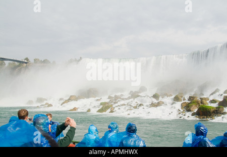 Touristen in blau parks immer sehr nass auf Maid of Nebel Boot an der berühmten Niagarafälle Regenbogen fällt Kanada New York USA Stockfoto