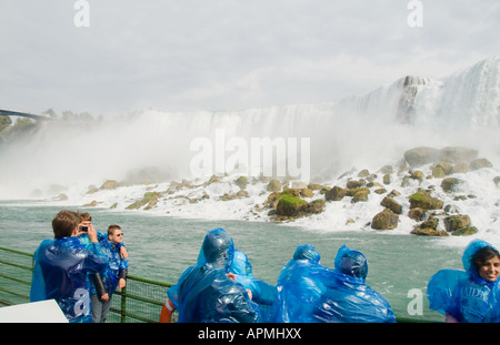 Touristen in blau parks immer sehr nass auf Maid of Nebel Boot an der berühmten Niagarafälle Regenbogen fällt Kanada New York USA Stockfoto