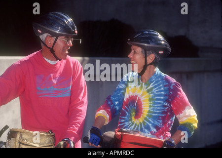 Älteres Paar in bunten Trikots und Bike-Helme, chatten vor der Wiederaufnahme der Radtour. Redondo Beach, CA USA Stockfoto
