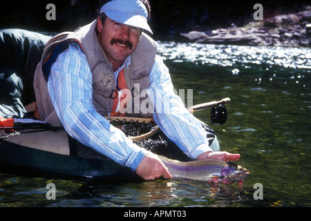 Fischer in Float Tube veröffentlicht Regenbogenforelle auf dem Green River, Utah Stockfoto