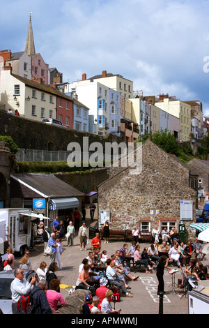 hilltop houses looking down over Tenby harbour, band entertaining tourists on the quayside, Pembrokeshire, Wales Stockfoto