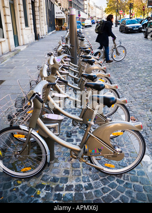 Radfahrer fährt von einem Zyklus Rack mit Velib Fahrradverleih in Paris, Frankreich Stockfoto