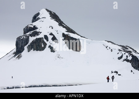 Schneebedeckte Berge und Touristen, Half Moon Island, Antarktis Stockfoto