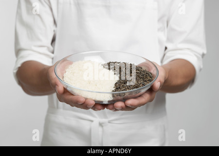 Koch hält Schüssel mit Weiß- und Wildreis (Mitte) Stockfoto