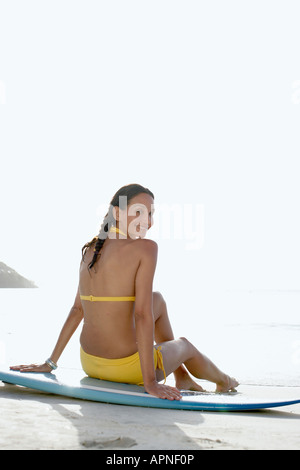 Junge Frau sitzt auf Surfbrett, St. John, US Virgin Islands, USA Stockfoto