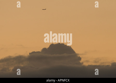 Düsenverkehrsflugzeug bei Sonnenuntergang Flting über den Wolken Stockfoto