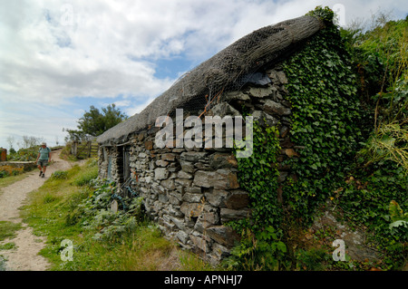 Fischer Hütte am niederließen Cove Prussia Cove Cornwall England und ein Mann zu Fuß den Küstenpfad Stockfoto