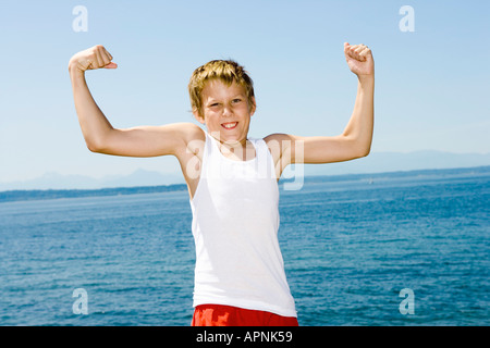 Kleiner Junge seine Muskeln Stockfoto