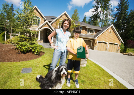 Mutter mit Sohn und Hund vor Haus Stockfoto