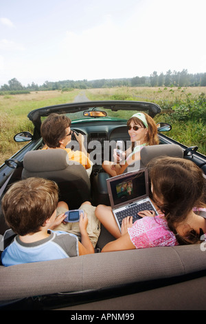 Familie im Cabrio mit tragbare Elektronik Stockfoto