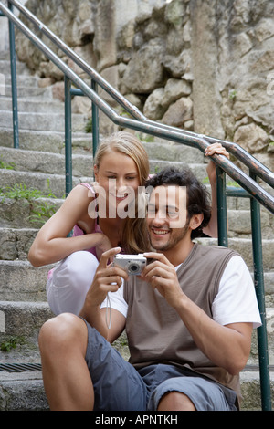 Junges Paar an Digitalkamera suchen Stockfoto