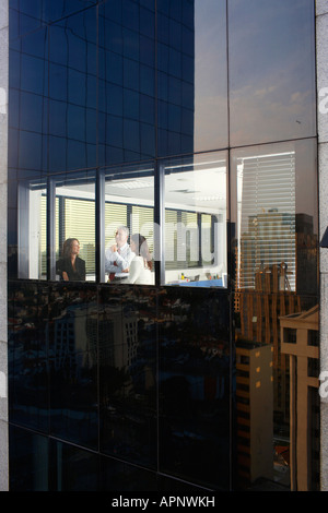 Drei Mitarbeiter im Büro arbeiten zu spät im Büro (Außenansicht) Stockfoto