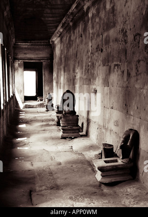 Auf der Suche nach einem alten steinernen Korridor mit den Überresten von stues auf der rechten Seite in Angkor Wat, Kambodscha Stockfoto