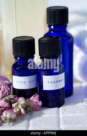 Ätherische Öle: Rosenöl und Rosmarinöl mit getrockneten Rosen Stockfoto