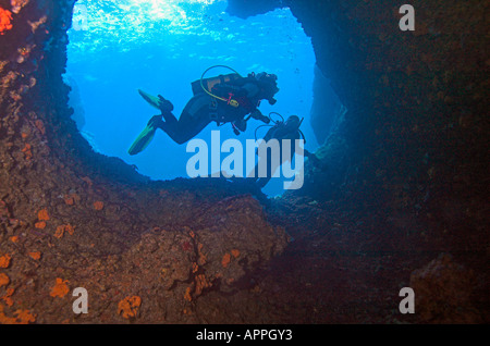 Blick aus der Höhle auf zwei Taucher Silhouette im Eingang zur Höhle Stockfoto