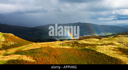 Regenbogen über Loughrigg Fell und Ambleside nach einem schweren Gewitter Frühling Ende Mai Seenplatte Cumbria England UK Stockfoto