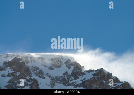 Wind weht Schnee von Bergrücken Stockfoto