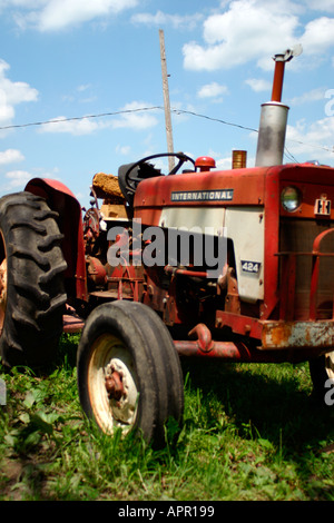 Traktor Bauernhof Equiptment ernten Hacke ländlichen grün blau Himmel Wolke Wolken rot Reifen antiken antiquierte Pflug Johannes Hirsch Sichelmäher Stockfoto