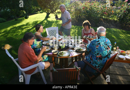 Eine Gruppe von Freunden mit Abendessen in einem englischen Country Garden in Großbritannien Stockfoto