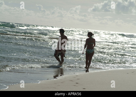 Paar im Schatten am frühen Morgen Bathsheba Strand entlang spazieren Stockfoto