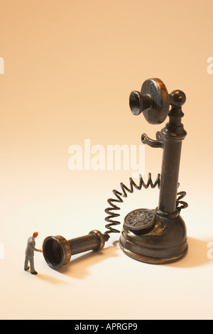 Geschäftsmann Figur mit antiken Telefon Stockfoto