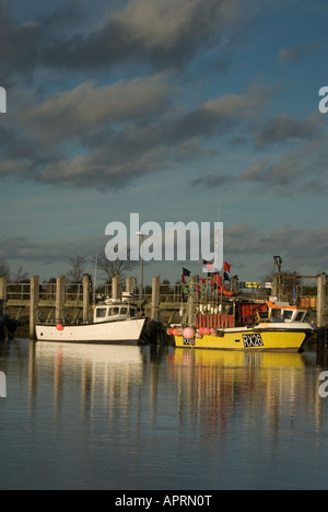 Zwei Boot vertäut im Hafen neben Quey man mit Angelausrüstung darauf Stockfoto