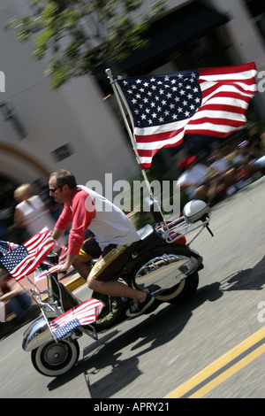 SCOOTER-FAHRER FLIEGT DIE STERNE UND STREIFEN WÄHREND DER FOURTH OF JULY PARADE IN SANTA BARBARA, KALIFORNIEN, USA Stockfoto