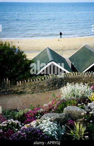 Blick vom Bournemouth Tropical Gardens Strand Hütte Dächer und einsame Figur am Strand, Bournemouth, Dorset Stockfoto