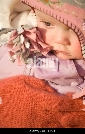 8 Monate altes Babymädchen eingehüllt in Winterkleidung Stockfoto