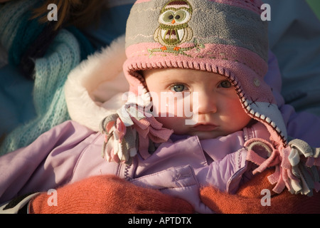 8 Monate altes Babymädchen eingehüllt in Winterkleidung Stockfoto