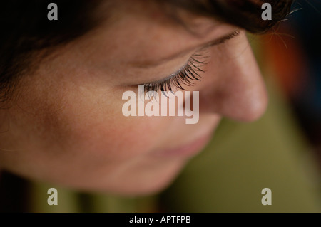 Nahaufnahme der jungen Frau in ihren frühen dreißiger Jahren, mit Schwerpunkt auf ihre Wimpern mit alles unscharf Stockfoto